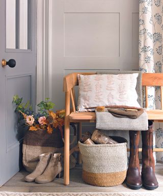 hallway. Crafted wooden bench with soft neutral throw and woven baskets.