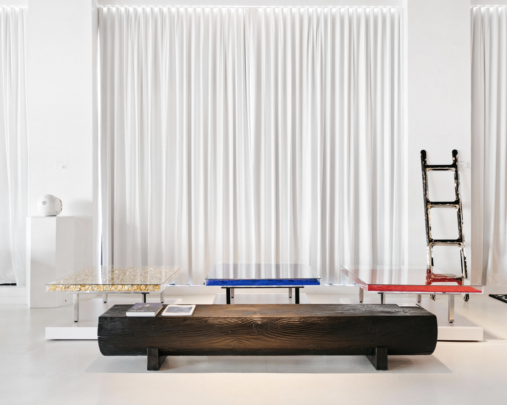 red, yellow and blue glass coffee tables in a white room