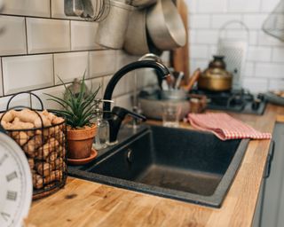 Black kitchen sink within a wooden-top counter