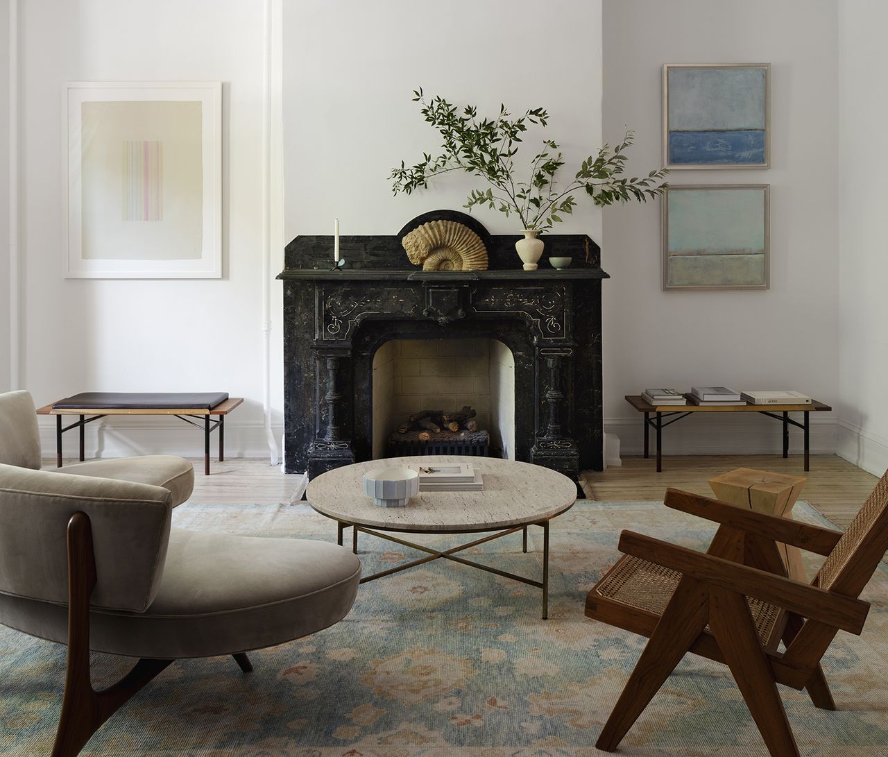 neutral living room with dark furniture and blue art on the walls