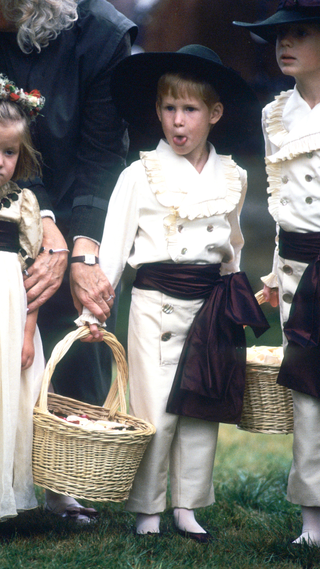 Cheeky Prince Harry sticks out his tongue as he stands with his cousins Eleanor Fellowes and Alexander Fellowes when he acts as a pageboy at the wedding of his uncle Charles Spencer (Viscount Althorp) on September 17, 1989 in Althorp, England
