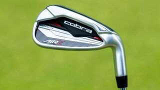 The Cobra Air-X Irons on a green background