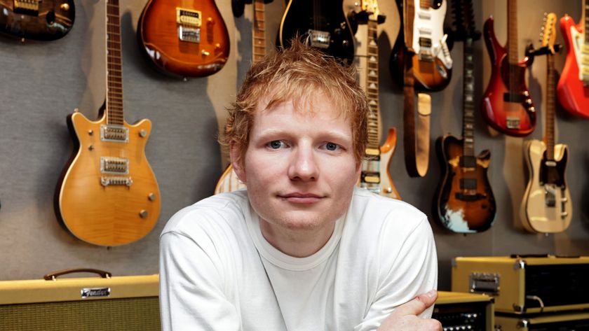 Ed Sheeran in front of guitars