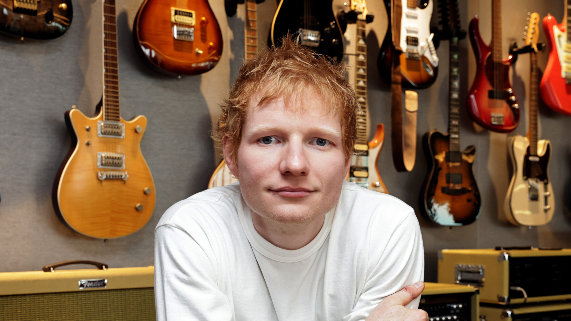 Ed Sheeran in front of guitars
