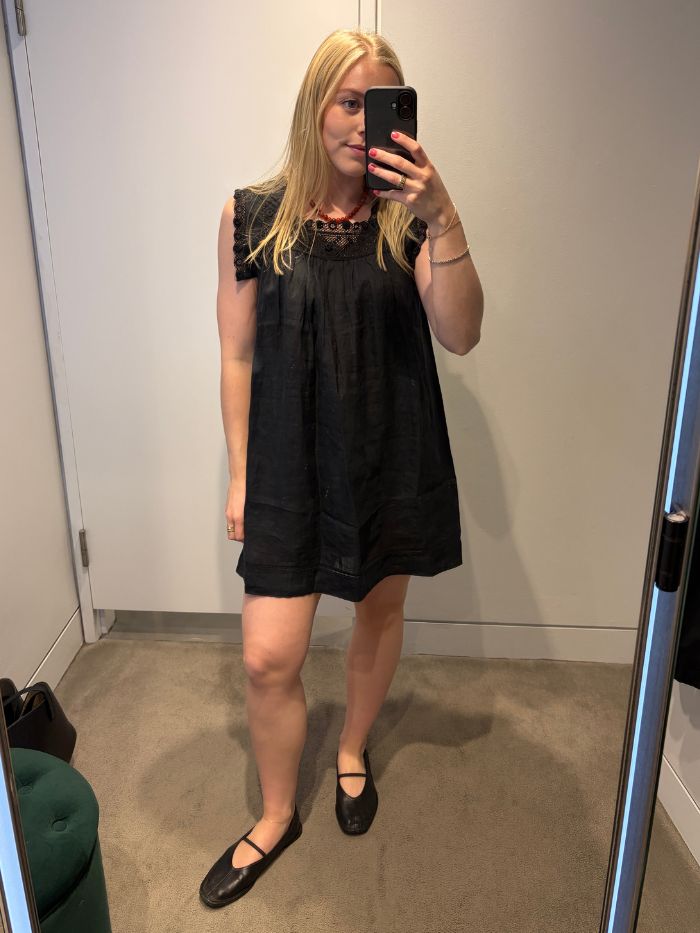 Woman wears Black Doen mini dress with black ballet flats