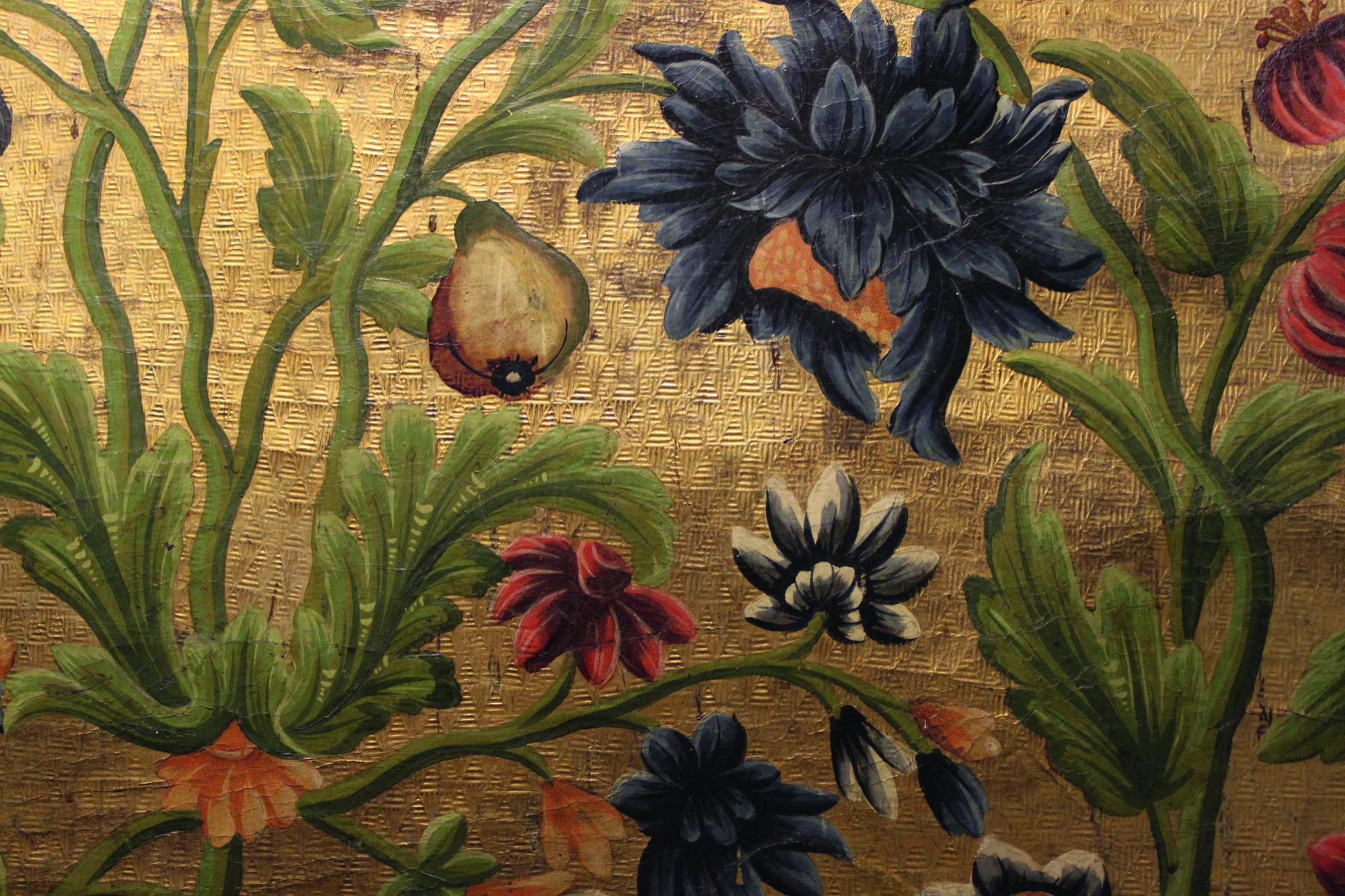 A close up of some gilt leather, showing flowers and plants