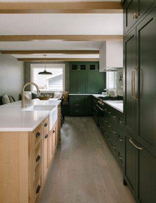 L-shaped kitchen with green cabinets and wood floor