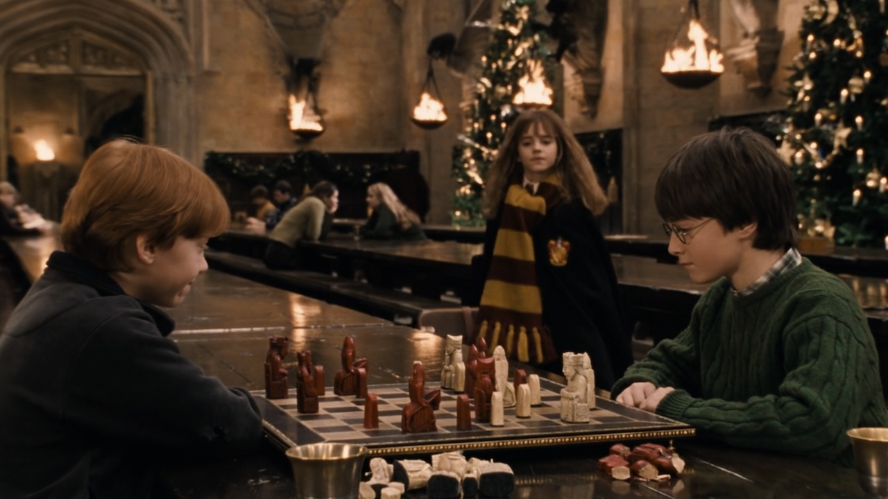 Hermione approaching Harry and Ron. as they play Wizard Chess in the great hall.