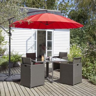 Decked area with outdoor dining set and red parasol