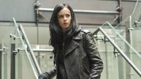 Krysten Ritter as Jessica Jones standing on staircase
