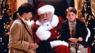 A still from the movie Miracle on 34th Street, one of the December's new Hulu movies, of santa claus talking to a little boy and his mom