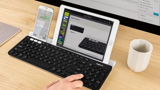 best iPad keyboard: Logitech K780 holding iPad and phone