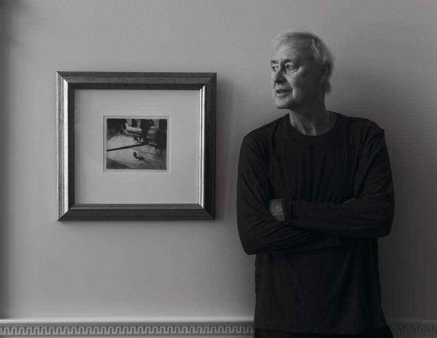 Bruce Hornsby standing next to a framed etching of Edward Hopper's Night Shadows