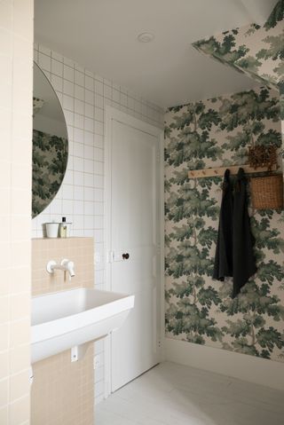 bathroom with tree wallpaper and white and peach tiles