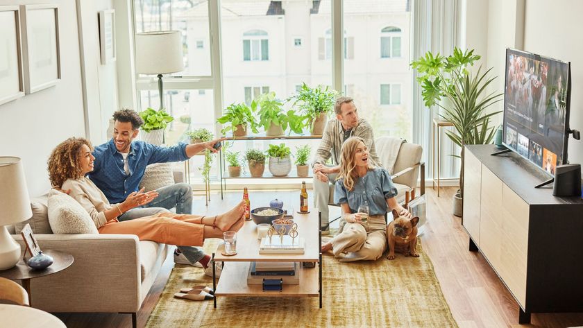 Image of a group of four people and a dog watching Sling TV in an apartment