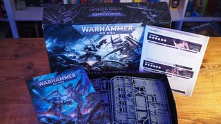 The Warhammer 40,000: Ultimate Starter Set and contents on a wooden table