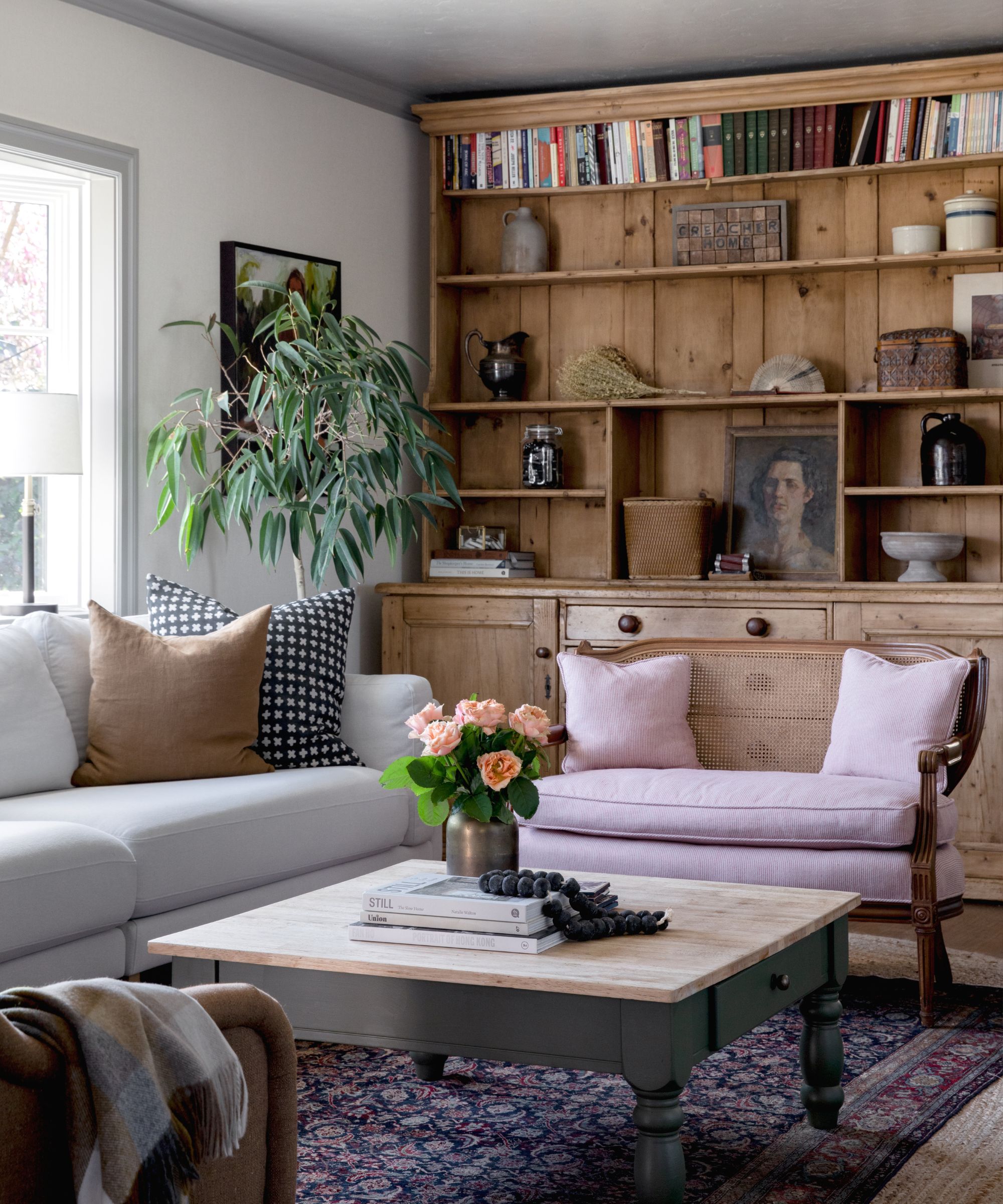 CM Natural Designs living room with a wooden dresser with collectibles and books