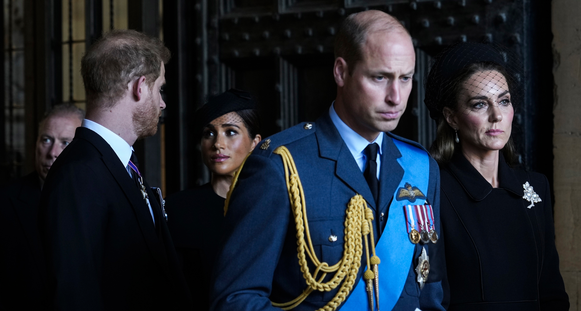 Prince William and Princess Kate standing in front of Prince Harry and Meghan Markle at Queen Elizabeth's funeral