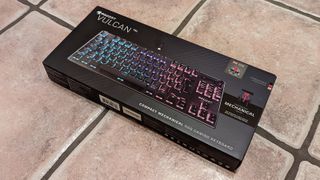 Roccat Vulcan TKL gaming keyboard in its box on some flagstones