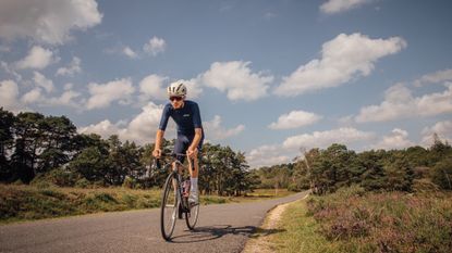 Male cyclist riding on a country lane on a sunny day