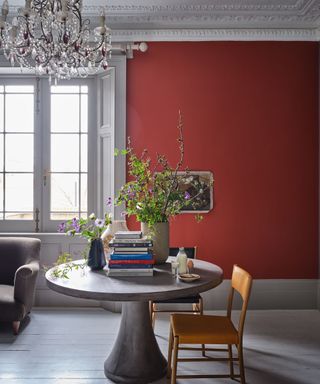 Deep red dining room with white window and dining table and wooden floor