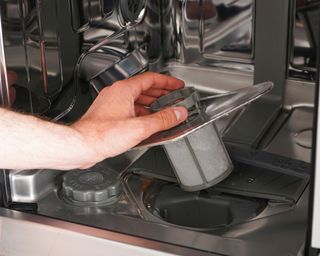 Man removing a dishwasher filter