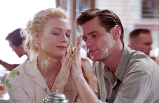 a blonde woman and Jim Carrey press their hands together in 'The Majestic'