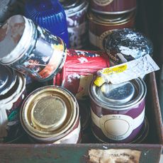 Paint tins in disorganised storage