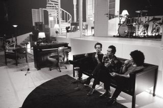 The 1975 stage Design with the band sitting on a sofa
