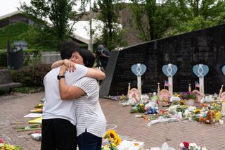 A mother and son embrace at a memorial for victims of the July 4th mass shooting in Highland Park, Illinois.