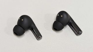 Écouteurs OnePlus Buds Pro 2 à côté des écouteurs originaux sur une table