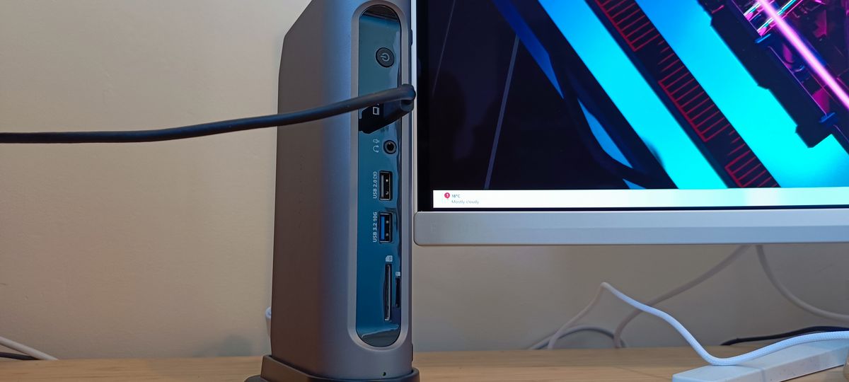 A grey Satechi Thunderbolt 4 dock sitting on a wooden desk