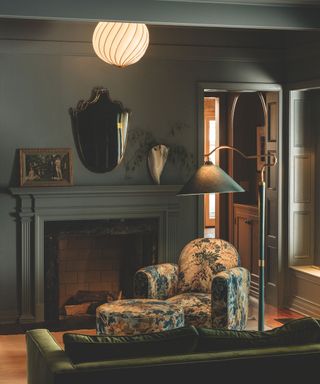 living room with dark walls and floral armchair