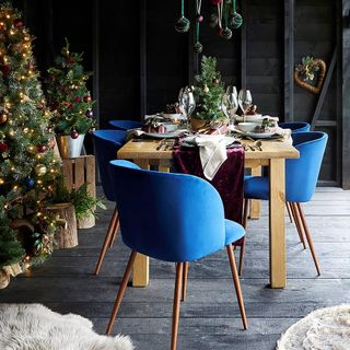 dining space with dining table having charger plates and blue wooden flooring