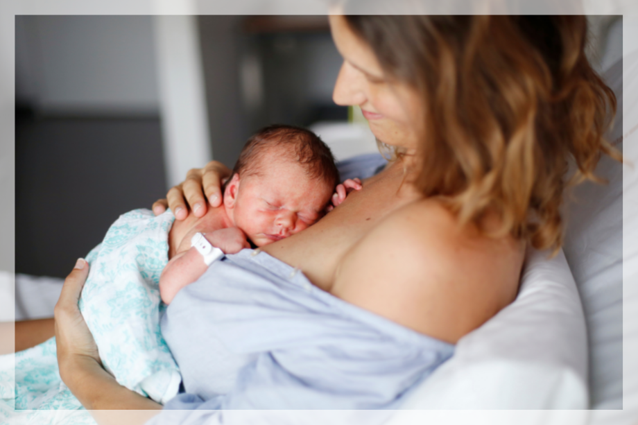 Woman holding a newborn following a VBAC delivery after caesarean