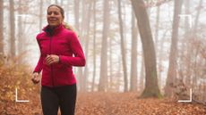 Woman running along path with autumn leaves on the ground in workout gear after learning how to work out in cold weather