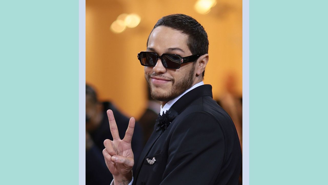 Pete Davidson giving the peace sign at The 2022 Met Gala Celebrating &quot;In America: An Anthology of Fashion&quot; at The Metropolitan Museum of Art on May 02, 2022 in New York City / on a blue and green background