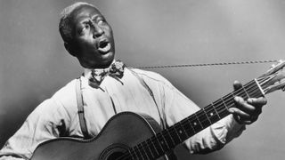 Lead Belly playin 12-string acoustic guitar