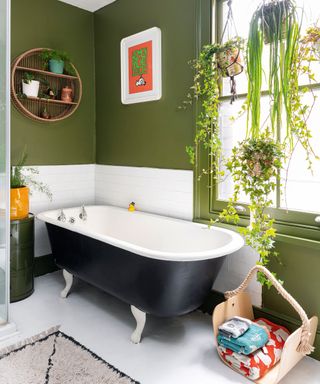 Green painted bathroom with roll top bath in east london victorian terrace