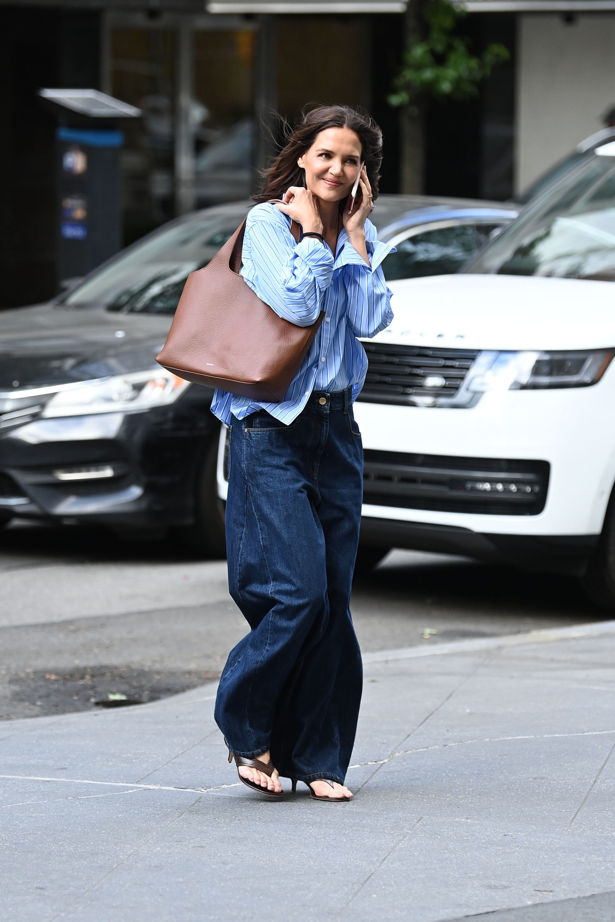 Katie Holmes holding Cuyana's System Tote in dark brown.