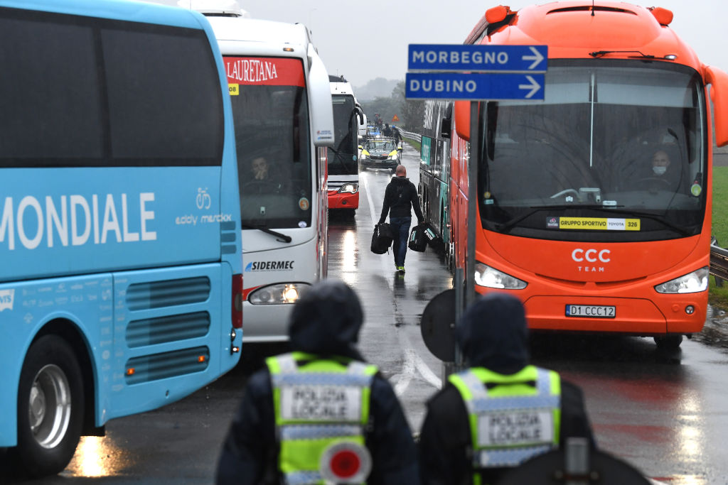 Riders head to their team buses for a transfer to the new start location