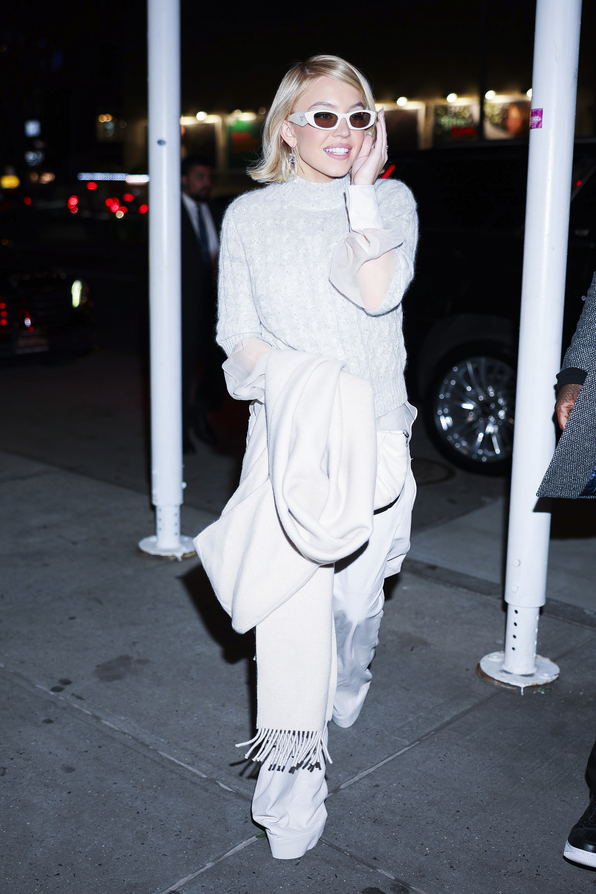 Sydney Sweeney was spotted in a chunky sweater layered over a sheer button down, all in light gray