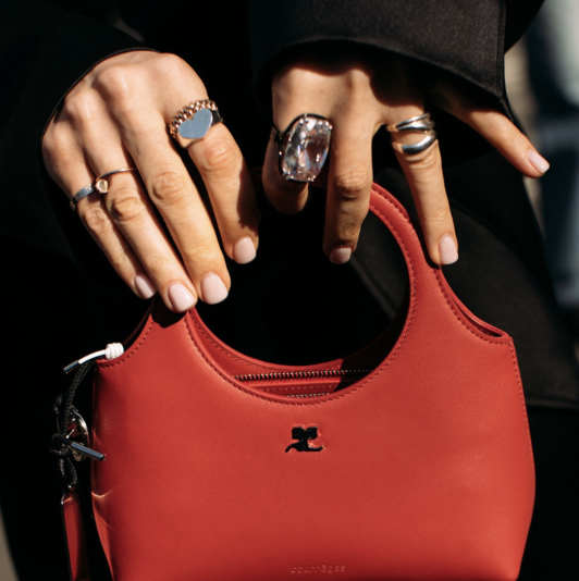woman wearing jewelry and holding red handbag 
