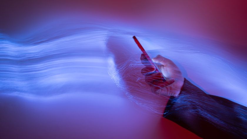 an image of a person holding a phone with waves of purple light emerging from it