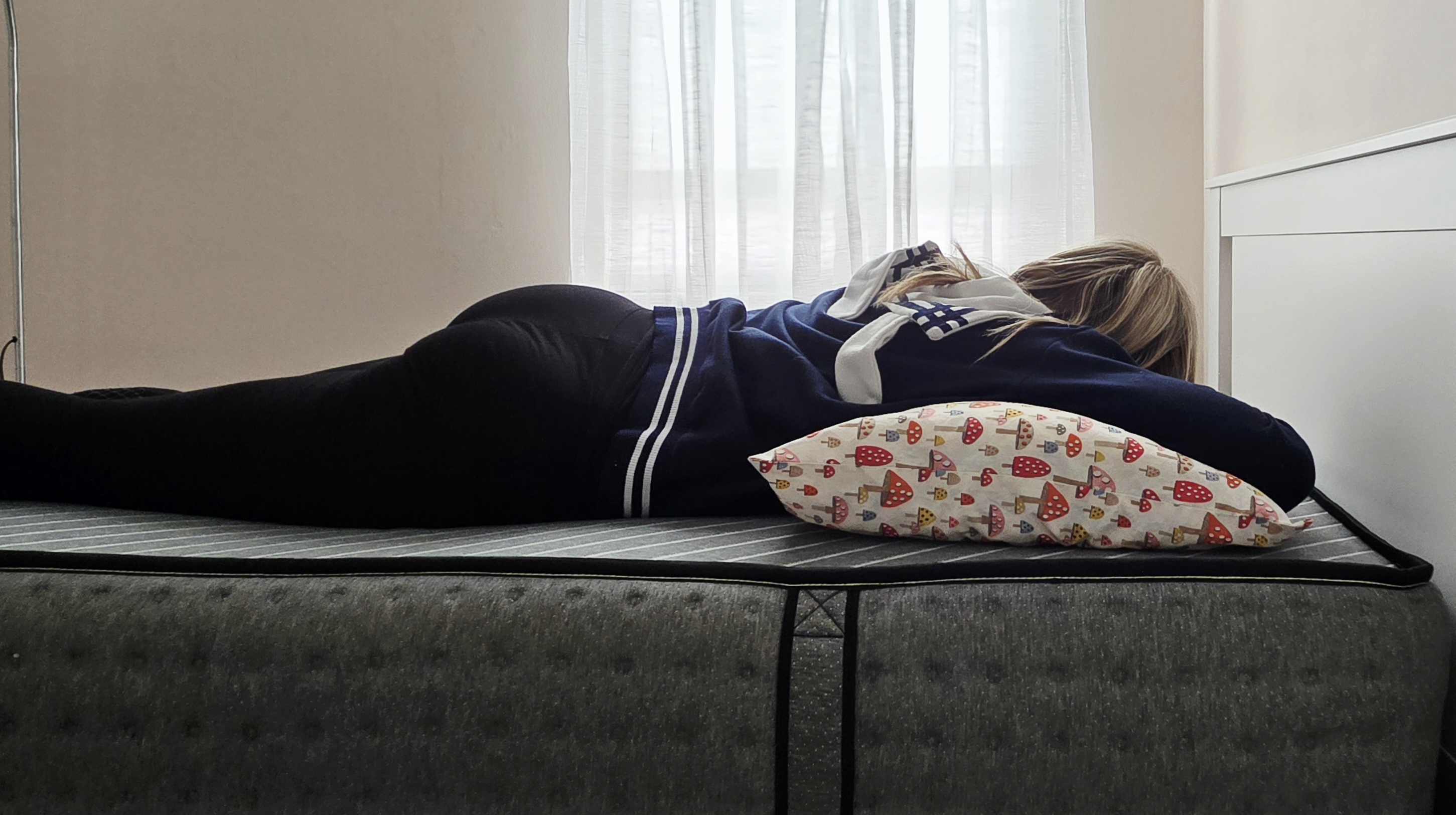 Mattress tester stomach sleeping on the Siena Premier Hybrid Mattress in her bedroom
