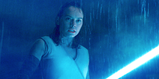 Rey, glowing under the light of her lightsaber