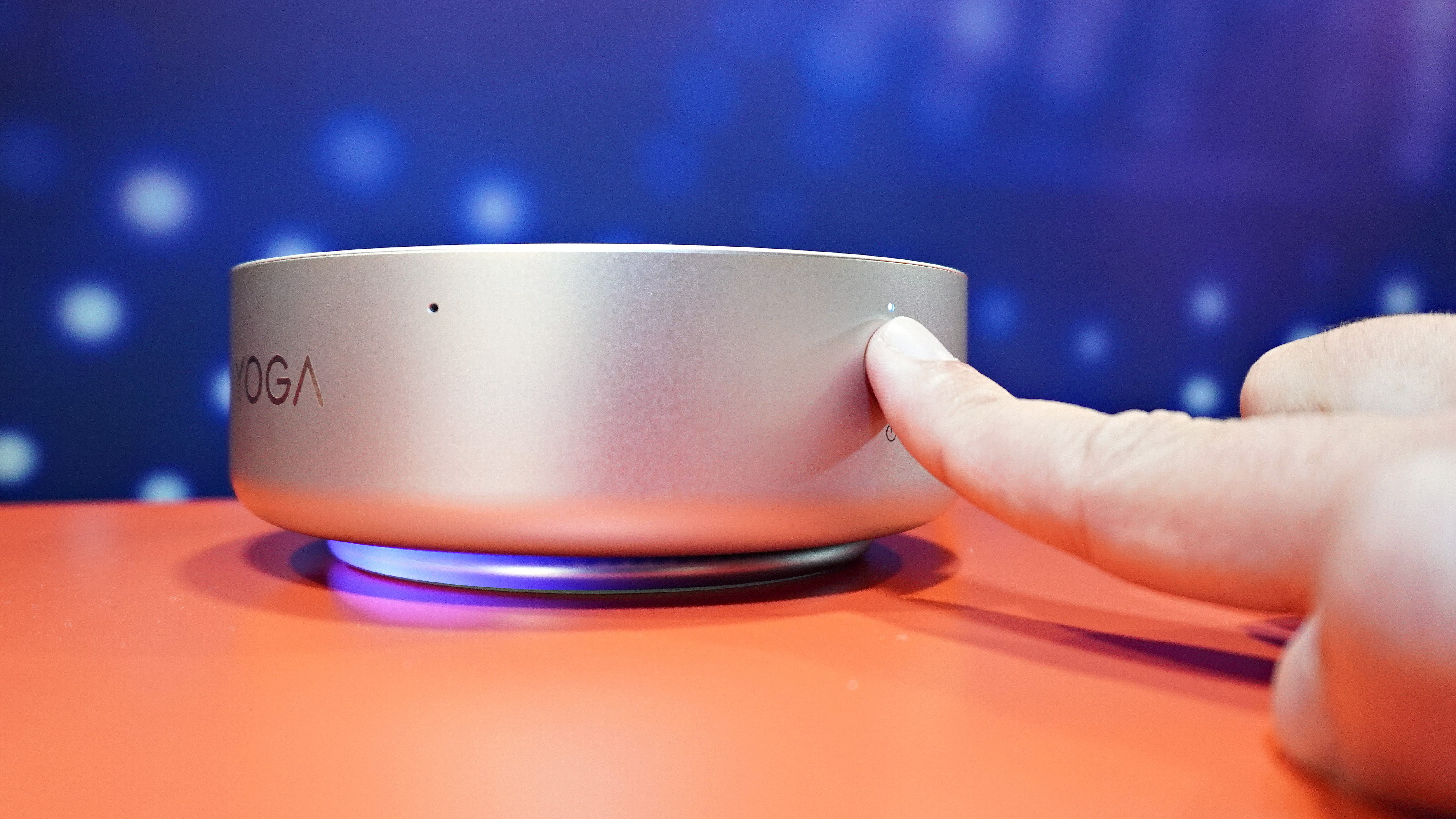A person placing finger on the Lenovo Yoga Mini i's power button which has a built-in fingerprint reader