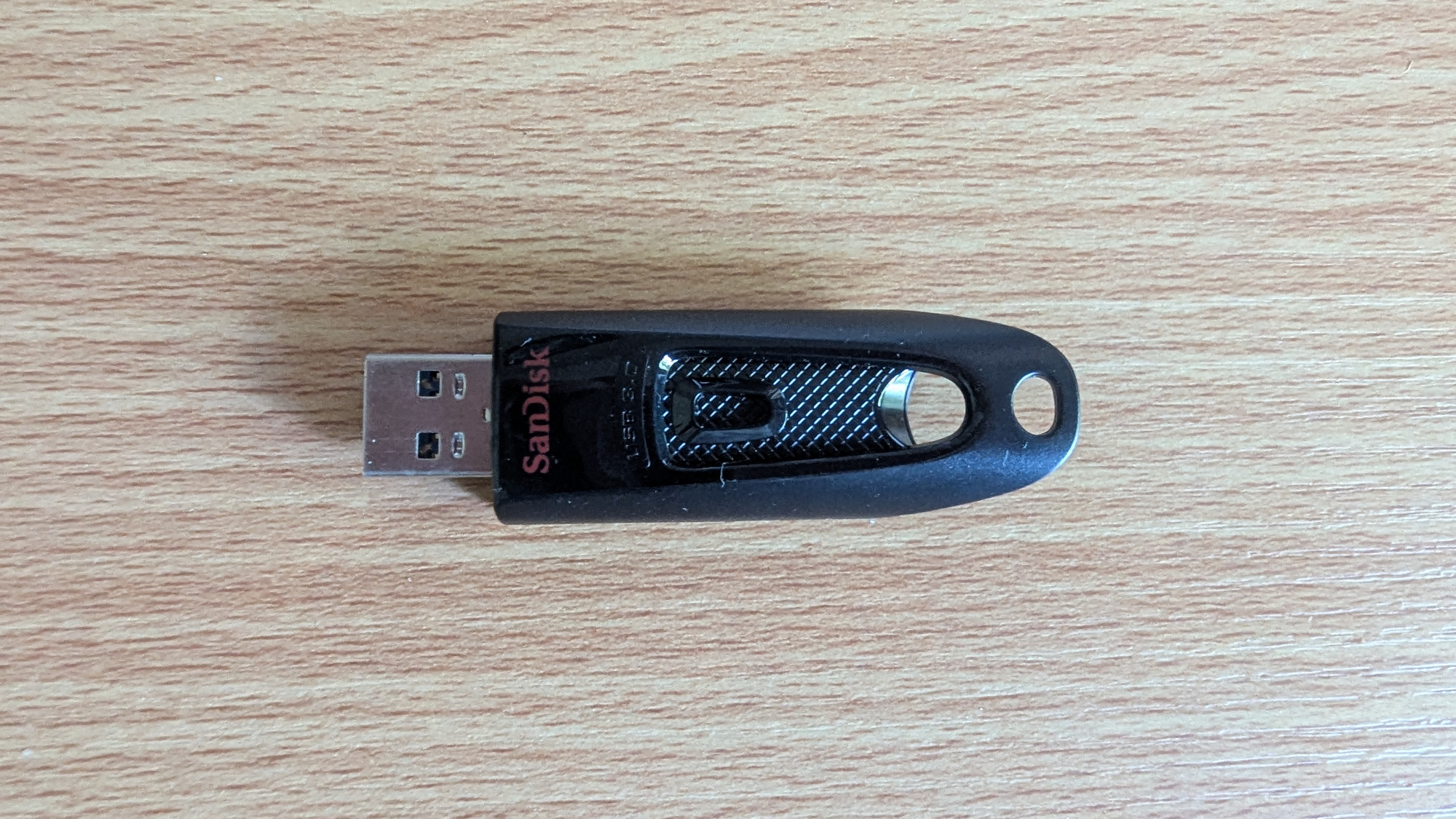 A SanDisk USB stick on a wooden desk
