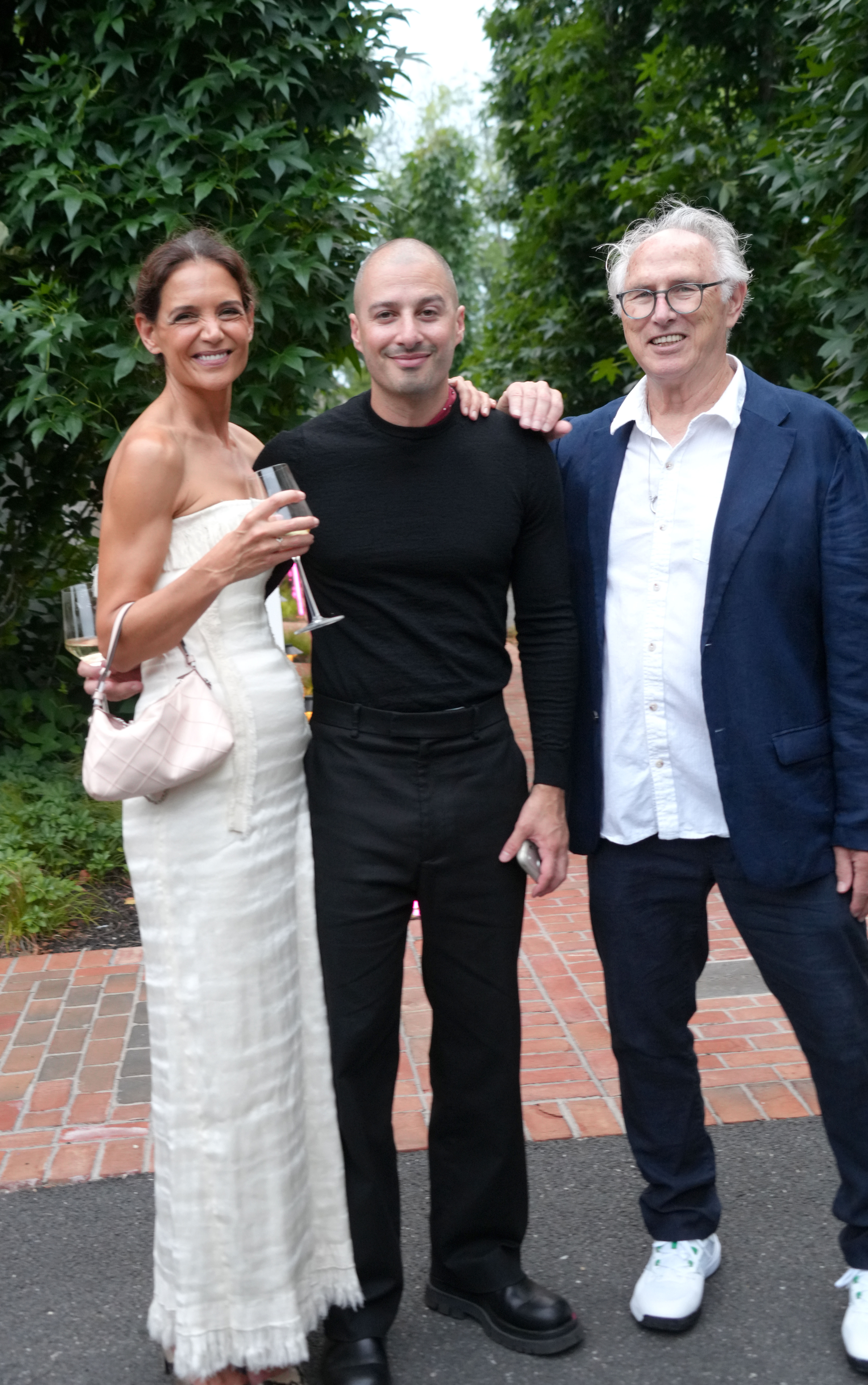 Katie Holmes wears a strapless white dress and carries a soft leather bag while posing with boyfriend Jason Bard Yarmosky at the 2026 Guild Hall Summer Gala on August 7, 2026