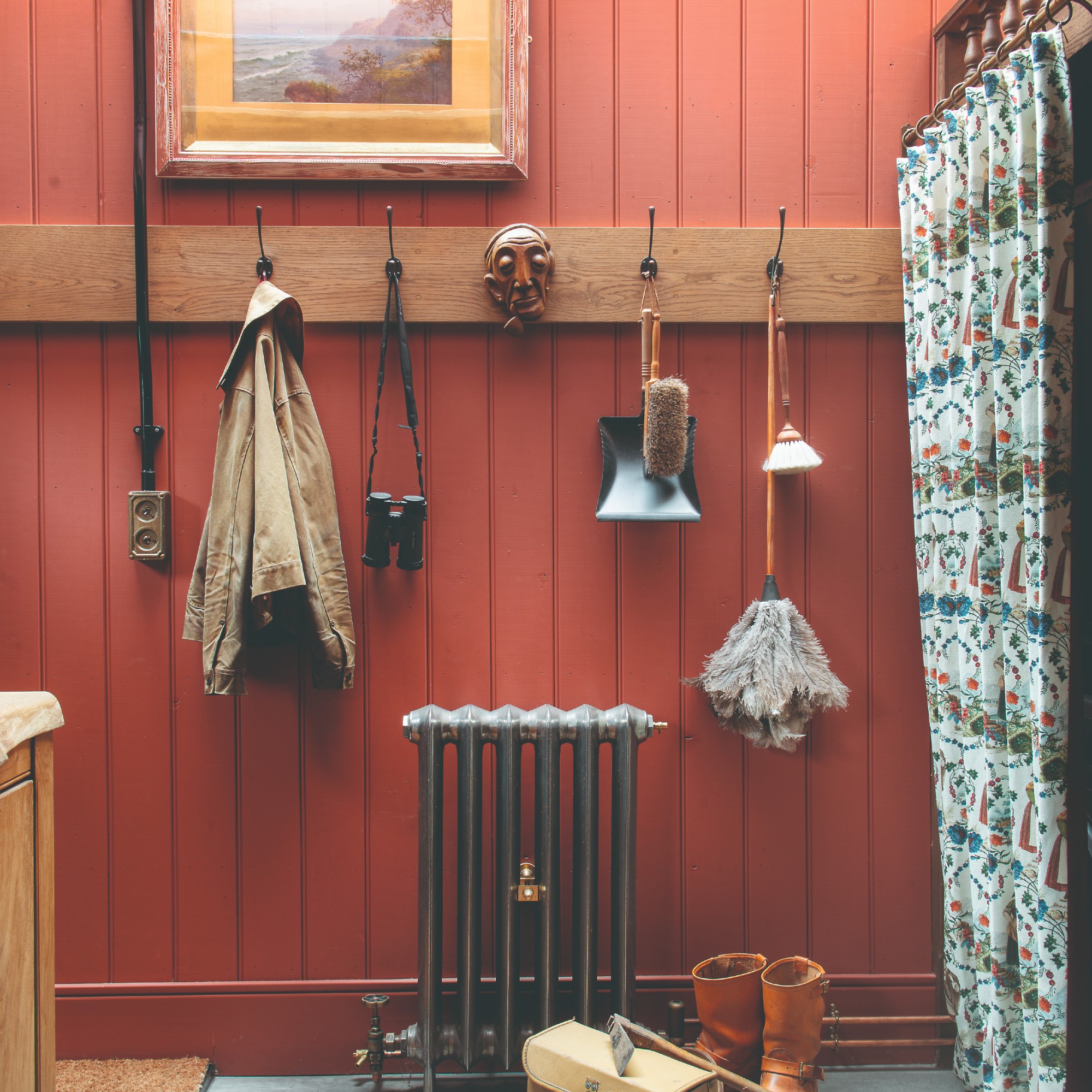 A hallway with terracotta-painted panelled wall
